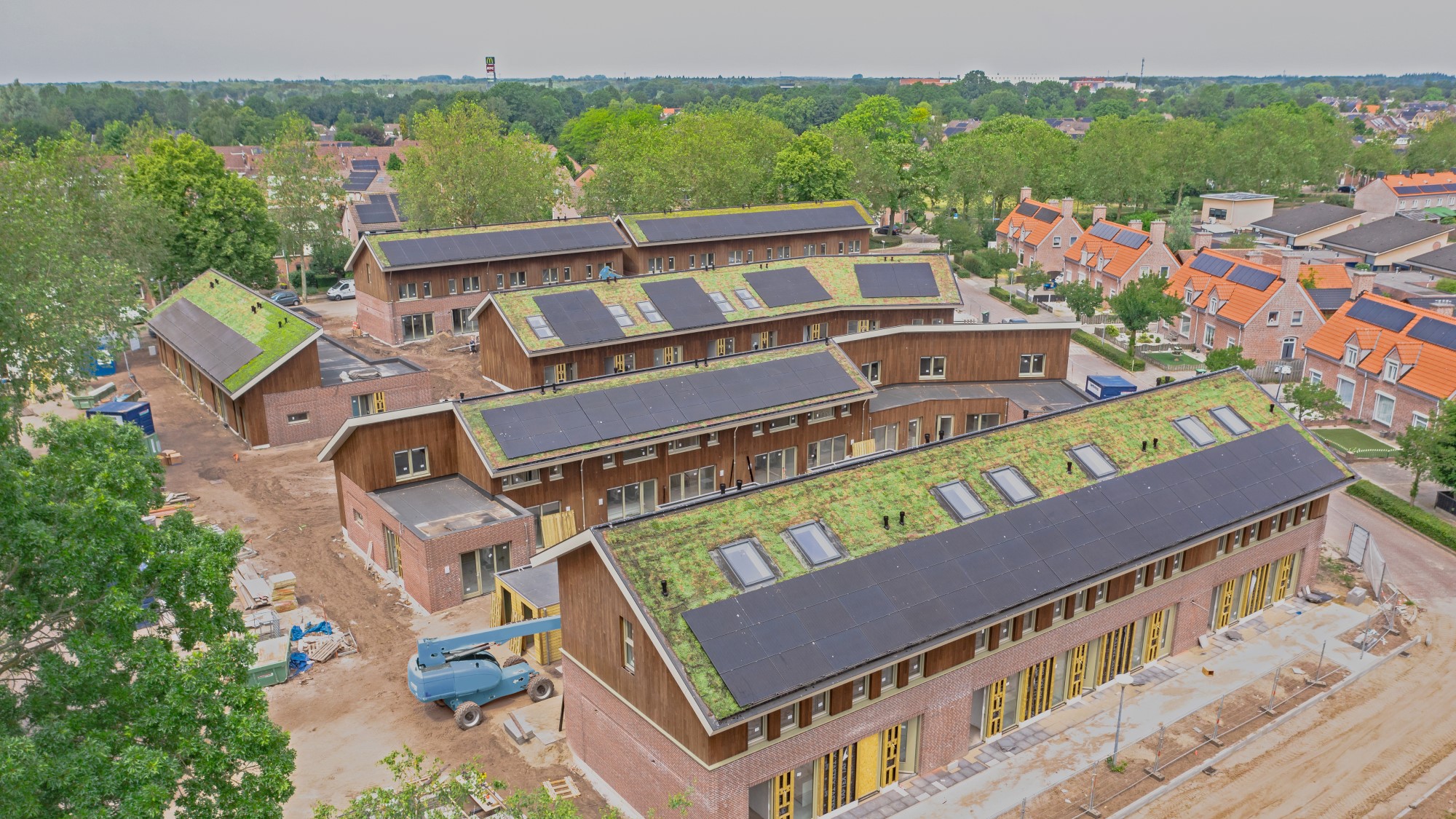 Hellende groene daken met zonnepanelen voor sociale huurwoningen in Uden